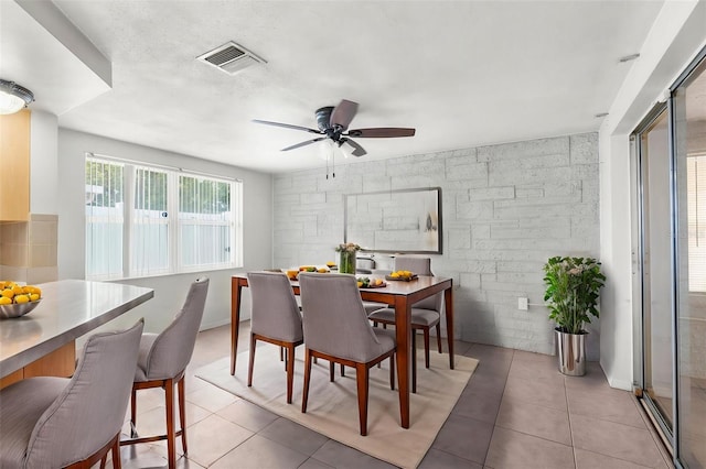 dining space featuring ceiling fan, visible vents, and light tile patterned floors