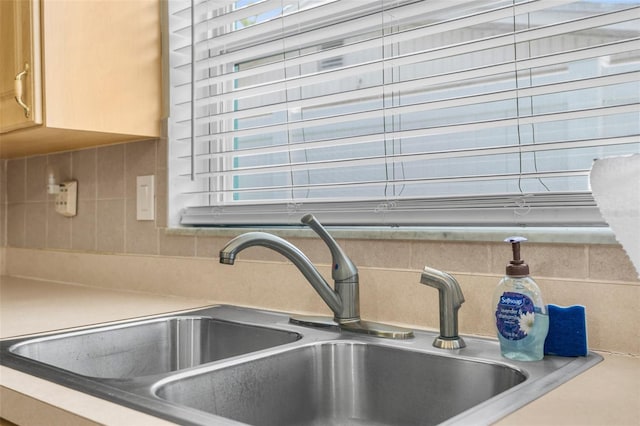 room details featuring backsplash, a sink, and light countertops
