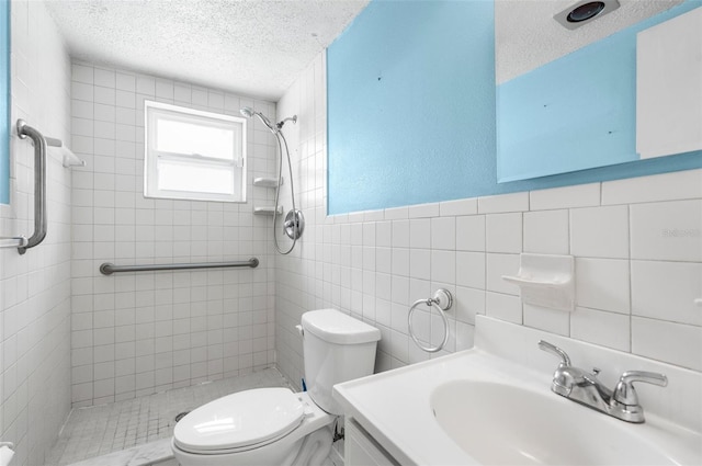 full bathroom featuring a textured ceiling, tile walls, a tile shower, vanity, and toilet