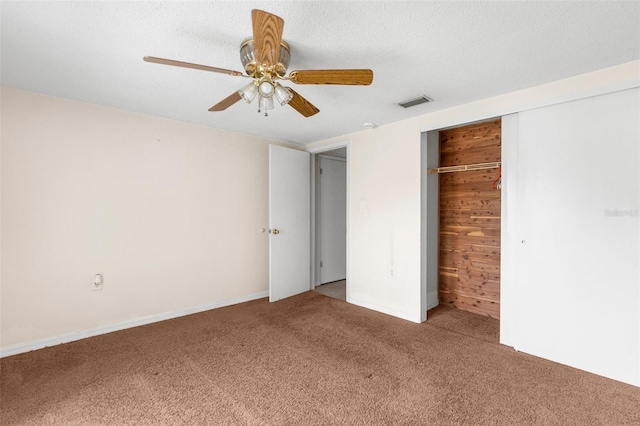 unfurnished bedroom featuring visible vents, a ceiling fan, carpet, and a closet