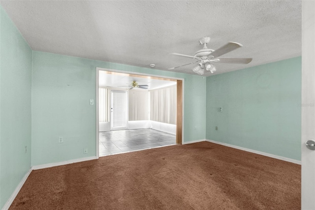 spare room with carpet floors, a ceiling fan, baseboards, and a textured ceiling