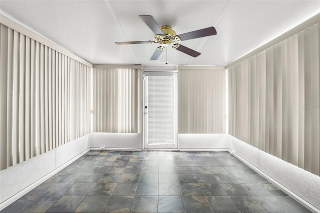 spare room with a ceiling fan and stone finish floor