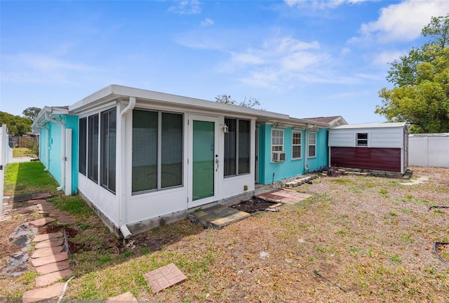 back of property featuring fence, a sunroom, and cooling unit
