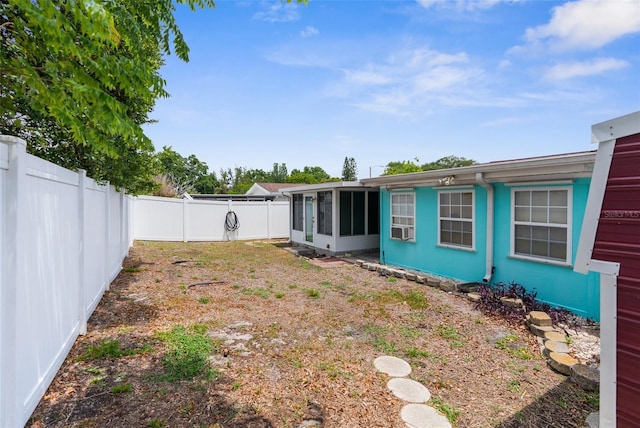 view of yard with a fenced backyard and a sunroom