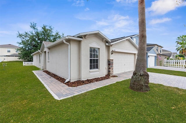 3410 Thistledown Ln, Land O Lakes, FL 34638 - view of home's exterior featuring fence, driveway, a yard, a garage, and stucco siding