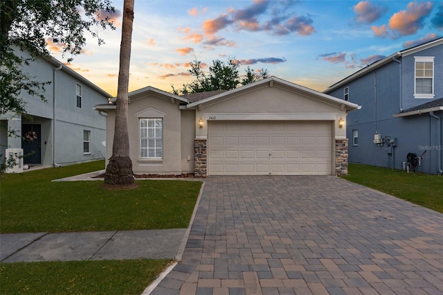 3410 Thistledown Ln, Land O Lakes, FL 34638 - view of front of property with stone siding, stucco siding, decorative driveway, and a yard