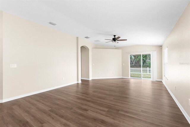 3410 Thistledown Ln, Land O Lakes, FL 34638 - spare room featuring dark wood-type flooring, baseboards, a ceiling fan, and arched walkways
