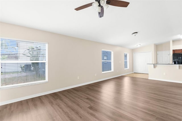 3410 Thistledown Ln, Land O Lakes, FL 34638 - unfurnished living room with light wood finished floors, lofted ceiling, baseboards, and a ceiling fan