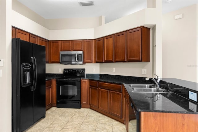 3410 Thistledown Ln, Land O Lakes, FL 34638 - kitchen featuring visible vents, a sink, a peninsula, dark stone countertops, and black appliances