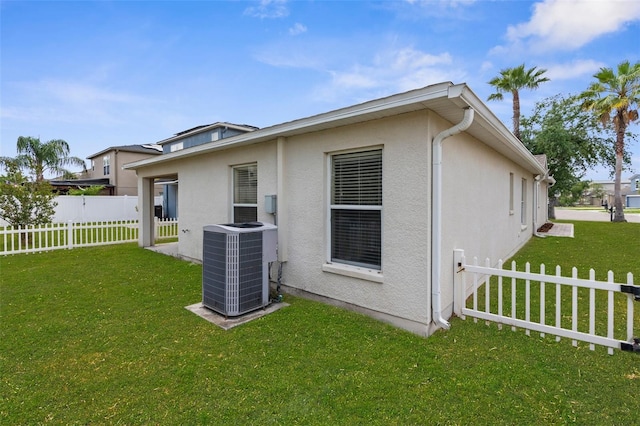3410 Thistledown Ln, Land O Lakes, FL 34638 - rear view of property with a lawn, cooling unit, stucco siding, and fence