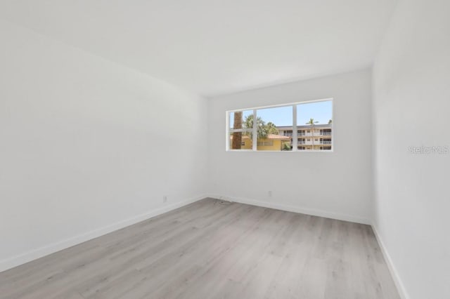 unfurnished room featuring light wood-type flooring and baseboards