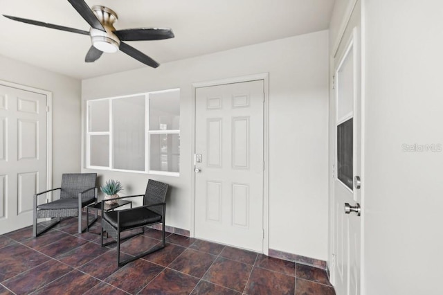 sitting room with baseboards and ceiling fan