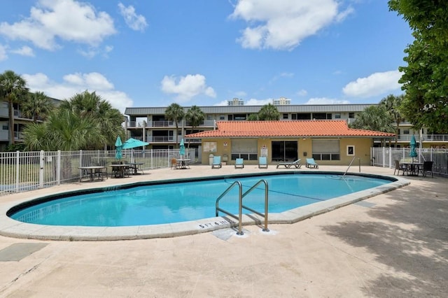 pool featuring fence and a patio area