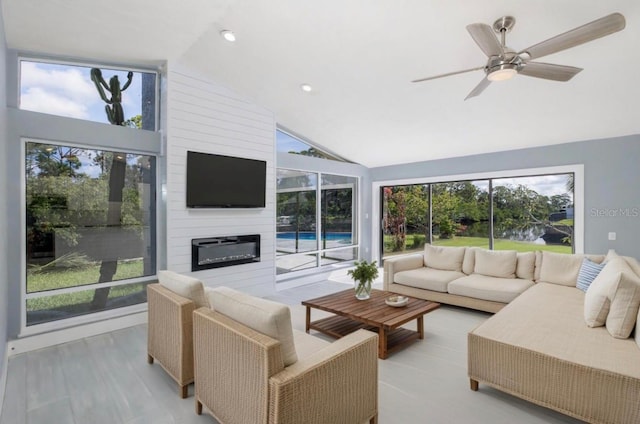 living area with plenty of natural light, ceiling fan, and high vaulted ceiling