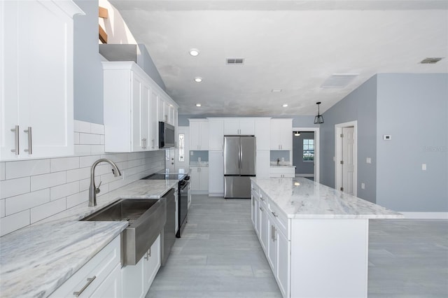 kitchen featuring a kitchen island, visible vents, appliances with stainless steel finishes, a sink, and recessed lighting