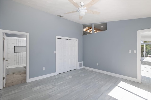unfurnished bedroom featuring baseboards, a closet, wood finished floors, and visible vents