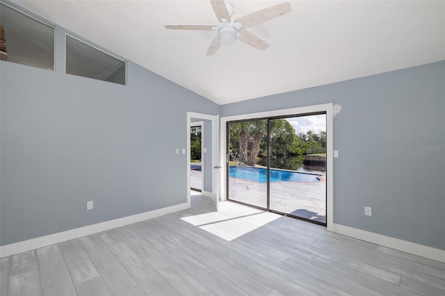 spare room with baseboards, ceiling fan, vaulted ceiling, and wood finished floors