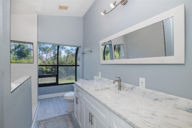 full bathroom with visible vents, a healthy amount of sunlight, toilet, and vanity