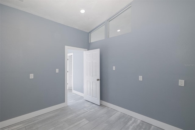 empty room featuring recessed lighting, baseboards, and wood finished floors