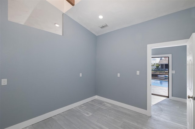 empty room featuring light wood-style floors, baseboards, recessed lighting, and visible vents