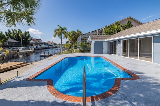 pool with a water view, a dock, and a patio area