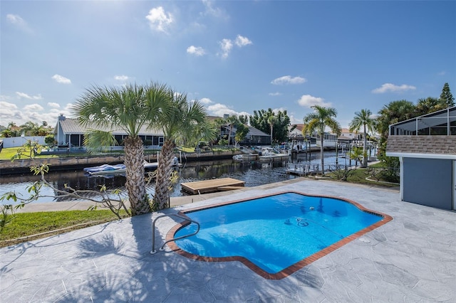 view of swimming pool featuring a patio, a water view, and a dock