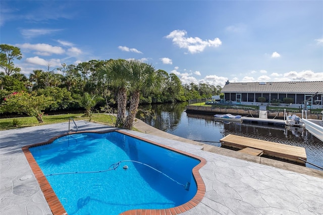 outdoor pool with a water view, a patio area, and a boat dock