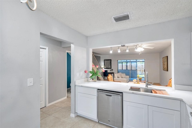 kitchen with a sink, dishwasher, white cabinetry, light tile patterned floors, and visible vents