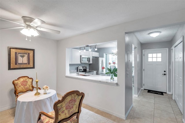 dining area with baseboards, a ceiling fan, a textured ceiling, and light tile patterned flooring