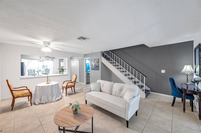 living room featuring a ceiling fan, visible vents, stairway, light tile patterned floors, and baseboards