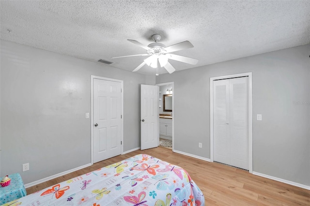 bedroom featuring visible vents, light wood-style floors, and baseboards