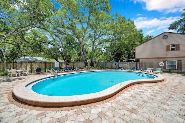 community pool featuring fence and a patio area