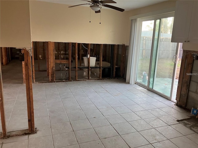 unfurnished room with light tile patterned floors, a ceiling fan, and a healthy amount of sunlight