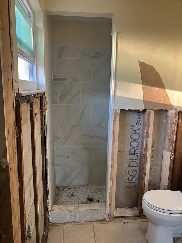 full bath featuring a tile shower and toilet