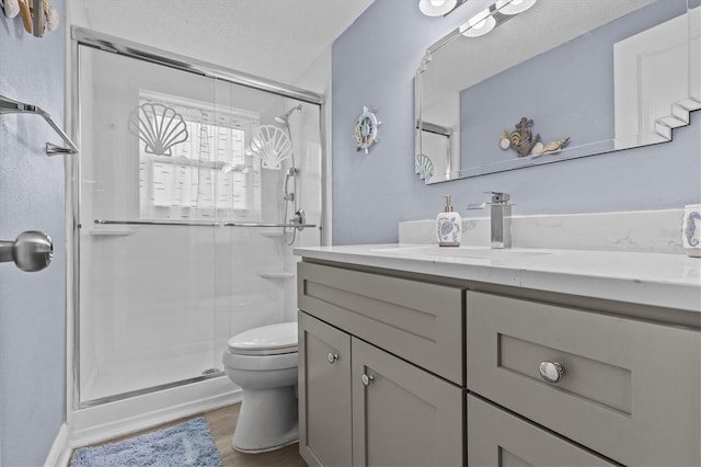 full bath with vanity, a stall shower, toilet, and wood finished floors