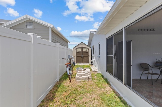 view of yard featuring an outdoor structure, fence, and a shed