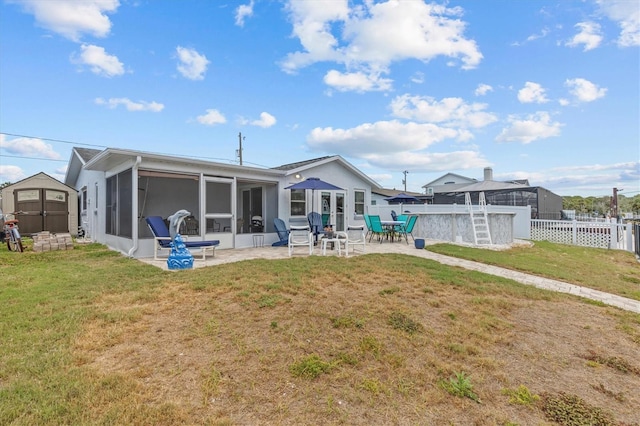 back of property featuring a fenced backyard, a sunroom, a storage unit, a patio area, and an outbuilding