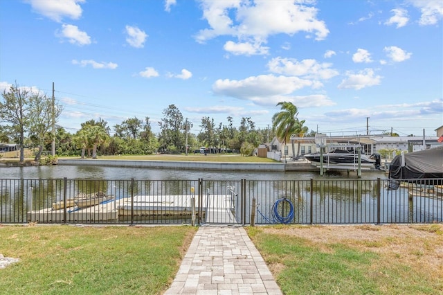 water view featuring fence, boat lift, and a dock