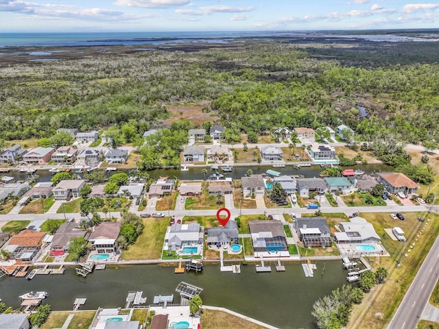 drone / aerial view featuring a water view, a residential view, and a forest view