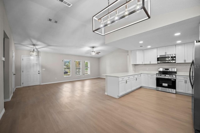 kitchen with visible vents, appliances with stainless steel finishes, light wood finished floors, a peninsula, and open floor plan