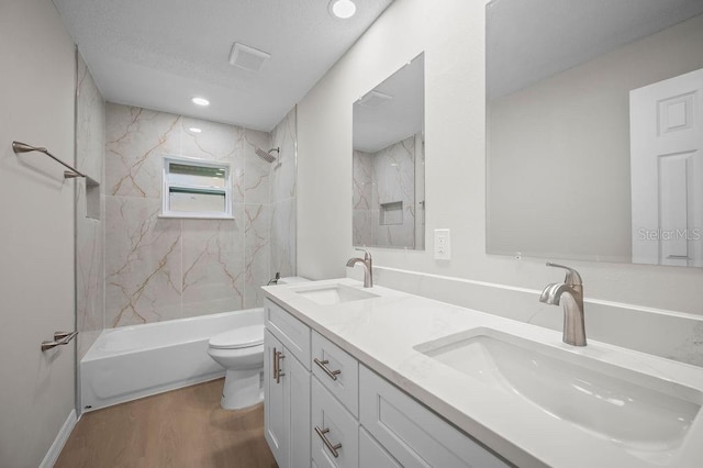 full bathroom with a sink, toilet, wood finished floors, and tub / shower combination