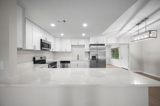 kitchen with visible vents, a sink, light stone counters, and stainless steel appliances