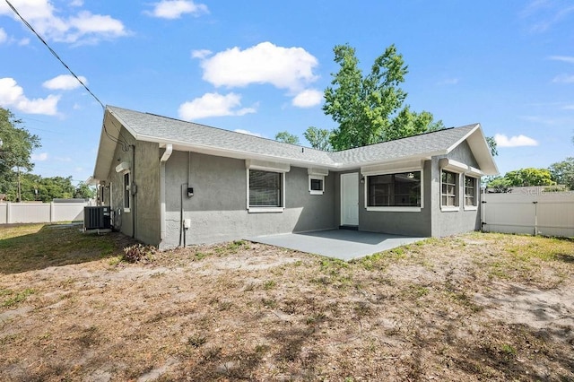 back of property featuring a patio, central AC unit, stucco siding, and a fenced backyard