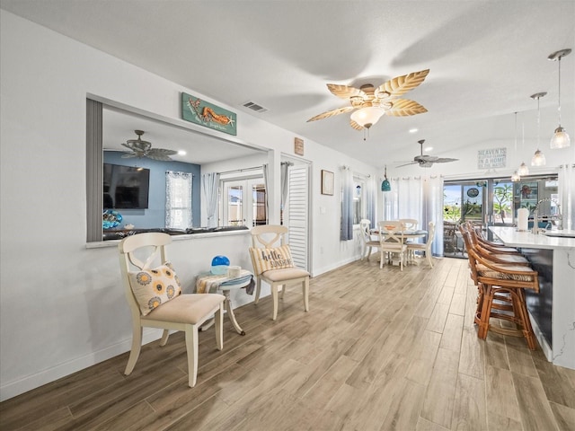 interior space featuring a ceiling fan, light wood finished floors, and visible vents