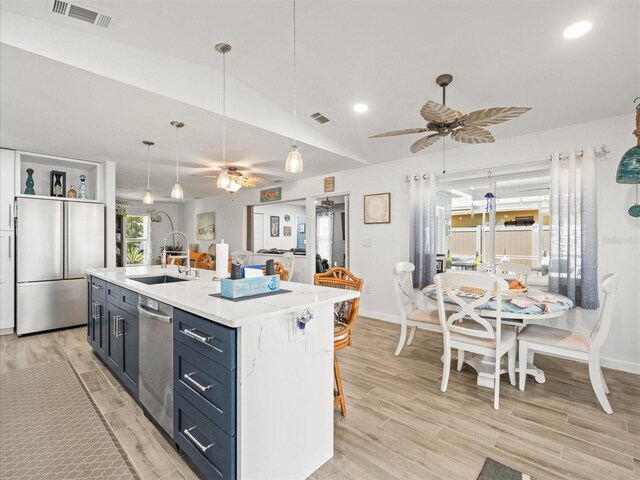 kitchen featuring stainless steel appliances, a ceiling fan, visible vents, and a sink