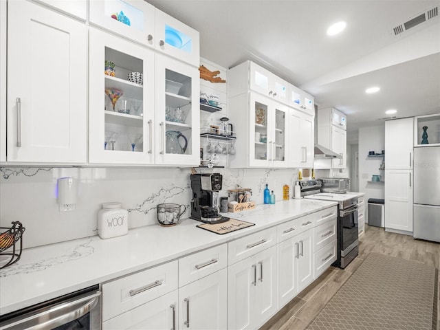 kitchen featuring range with electric cooktop, beverage cooler, visible vents, built in fridge, and light wood-type flooring