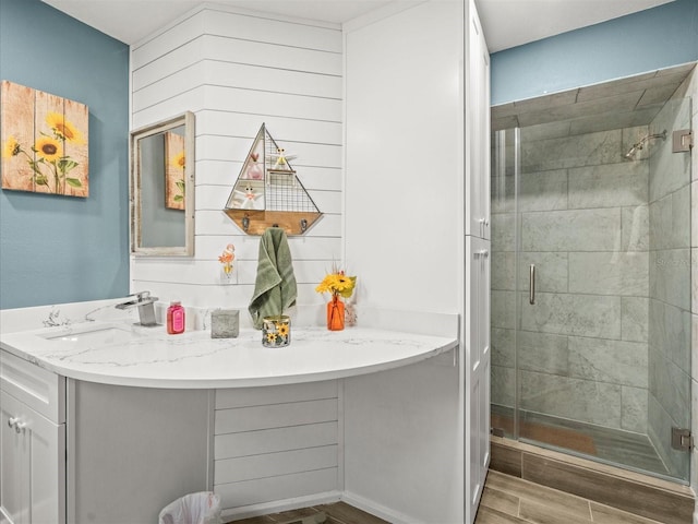 full bath featuring vanity, a shower stall, and wood finished floors