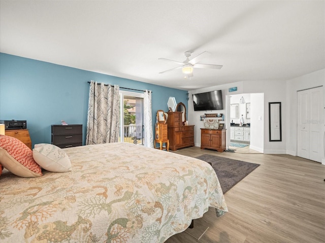 bedroom with a ceiling fan, a closet, baseboards, ensuite bathroom, and wood finished floors