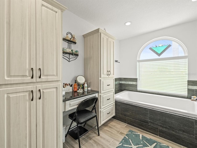 full bath with a bath and wood finished floors