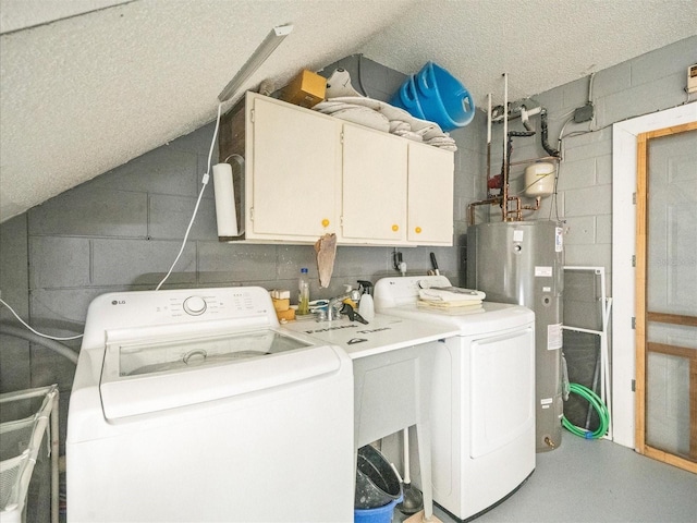 laundry room with water heater, concrete block wall, cabinet space, and washer and dryer